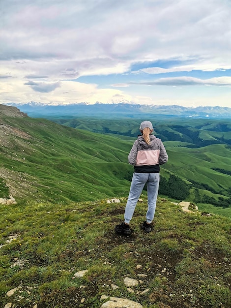 Een meisje op de klif van het plateau tegen de achtergrond van de berg Elbrus Bermamyt
