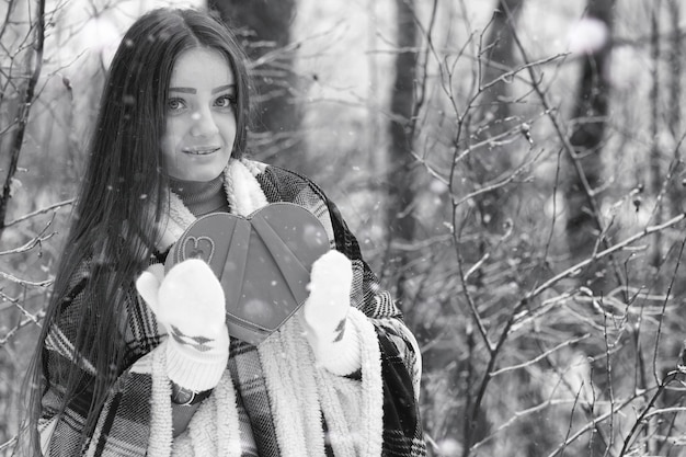 Een meisje op een bewolkte winterdag van besneeuwde velden en bossen