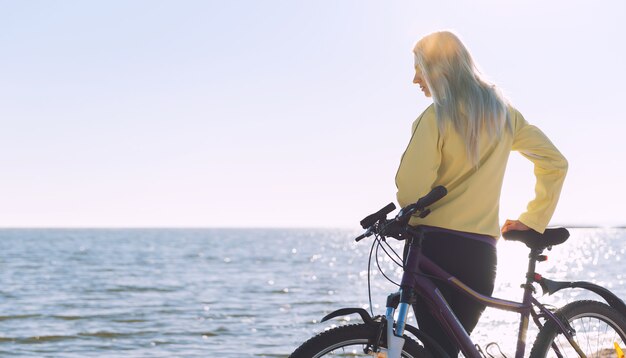 Een meisje op een fiets aan zee