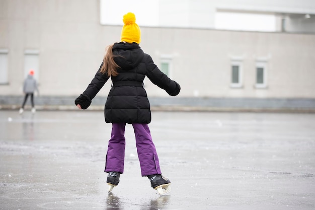 Een meisje schaatst op ijs in de winter.