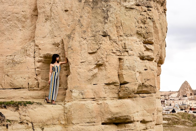 Een meisje staat op een rots en kijkt naar de rotsformaties in Cappadocië. Kalkoen