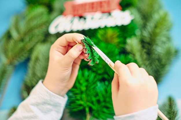 Een meisje tekent een kerstboom en bereidt zich voor op het nieuwe jaar 2022. Prettige kerstdagen en een gelukkig nieuwjaarsconcept