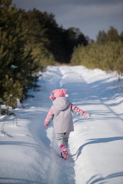 Een meisje wandelt in het bos in de winter
