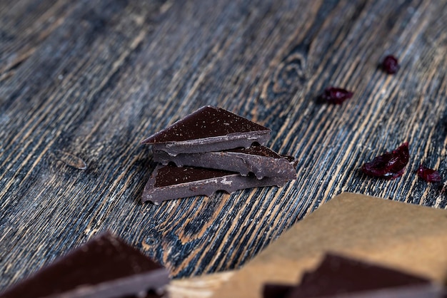 Foto een melkchocoladereep die in een groot aantal stukjes is gebroken, stukjes melkchocolade liggen op tafel