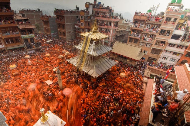 Een menigte mensen in oranje en rood heeft zich verzameld in een drukke straat.