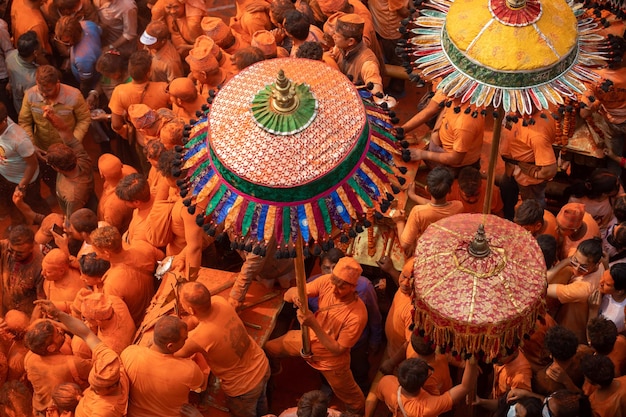 Een menigte mensen in oranje heeft zich verzameld in een druk gebied met een kleurrijke hoed erop.