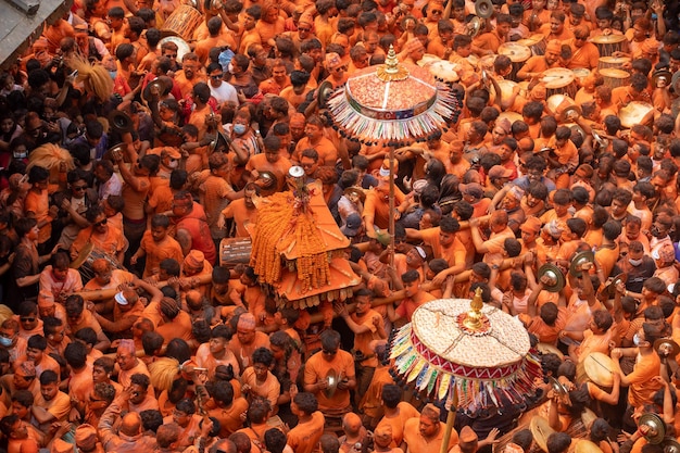 Een menigte mensen met oranje shirts en oranje shirts heeft zich verzameld op een festival.