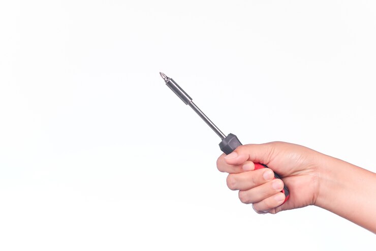 Een mensenhand houdt een schroevedraaier op witte achtergrond