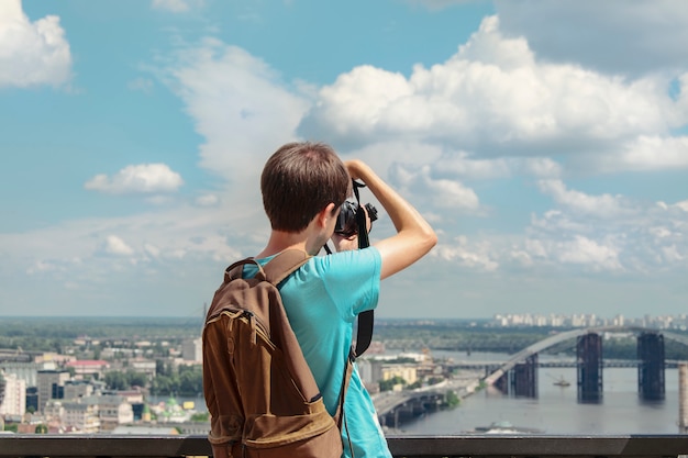 Een mensfotograaf fotografeert een mening van de mooie stad, mening van de rug.