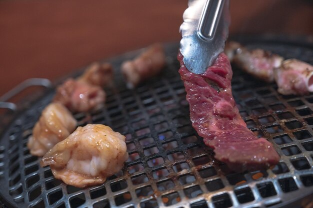 Een mes dat een stuk vlees op een grill snijdt