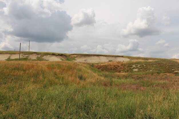 Een met gras begroeide heuvel met wolken in de lucht