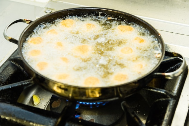 Foto een metalen pot kroketten op gasfornuis