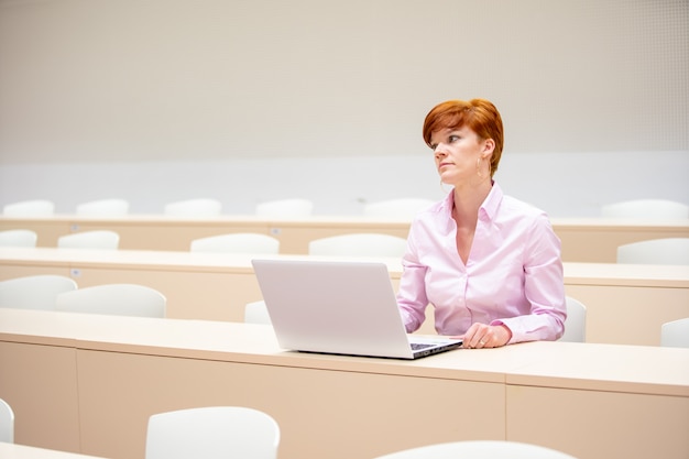 Een middelbare schoolleraar schrijft huiswerk voor studenten in zijn witte laptop