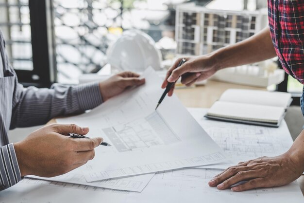 Een middendeel van ingenieurs die aan een blauwdruk werken op tafel.