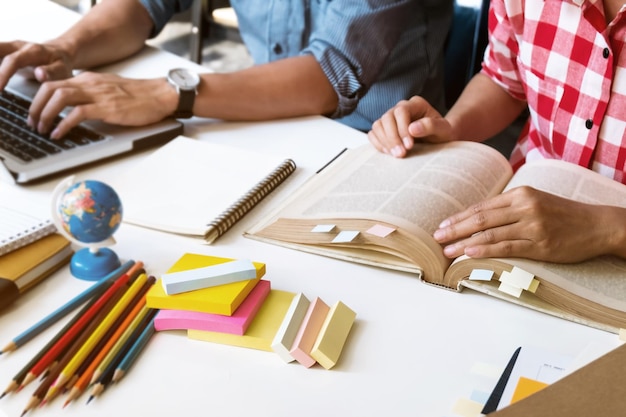 Een middengroep vrienden die aan tafel in de bibliotheek studeren.