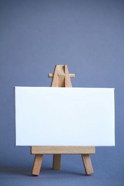 Een miniatuur-ezel met een wit bord om te schrijven, aanwijzer op wit oppervlak