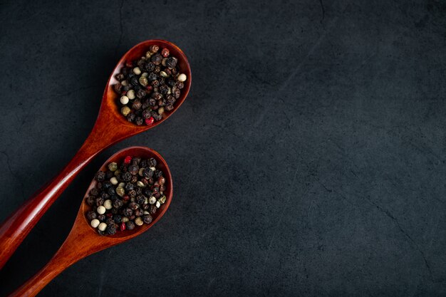 Een mix van rode en zwarte peper in houten lepel