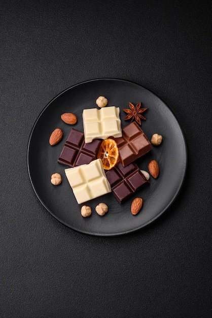 Een mix van verschillende soorten heerlijke zoete chocolade in blokjes gebroken op een zwarte plaat
