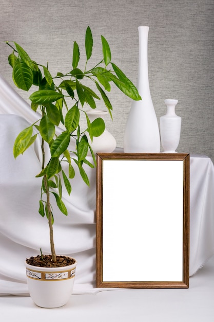 Een mock-up van een frame, boom en vazen op tafel