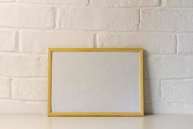Een mock-up van een houten frame voor een foto of een afbeelding op een tafel met een kopie van de ruimte. Scandinavische stijl.