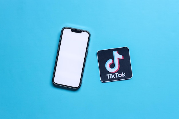 Een mockup van een smartphone met een leeg scherm met gedrukt papier van het logo van de sociale media-applicatie genaamd Tiktok