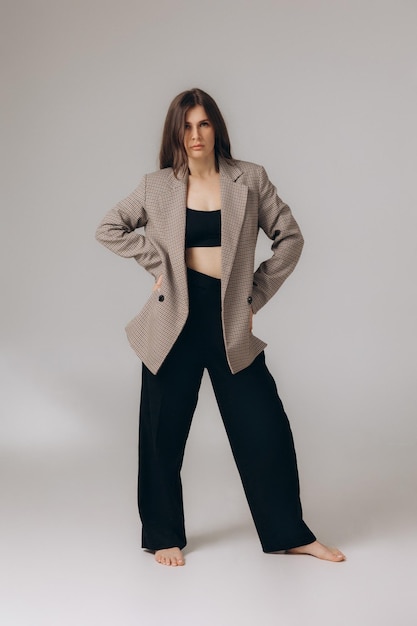 Een model draagt een blazer en broek met een zwarte top.