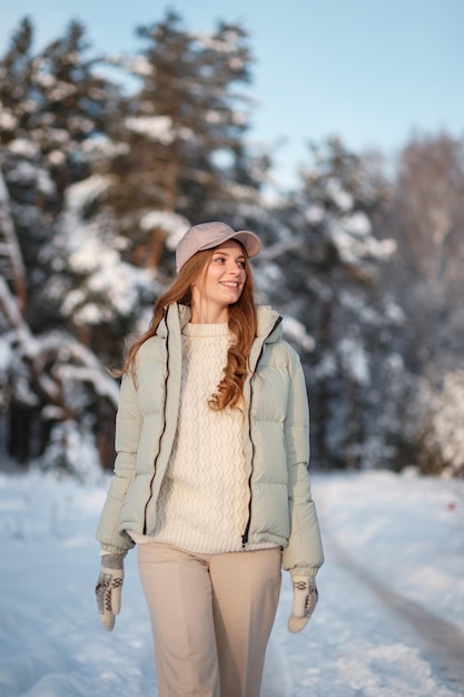 Een modelmeisje dat door een besneeuwd bos loopt, een demonstratie van kleding