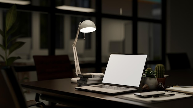 Een modern bureau in een donkere kantoorruimte 's nachts met laptopmodel