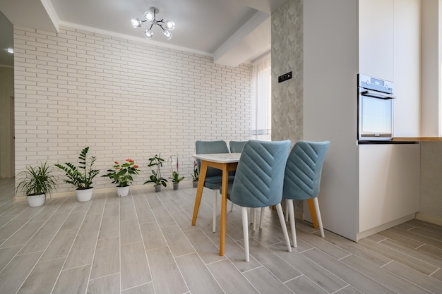 Een modern wit studio-appartement met een eettafel en een rij groene planten