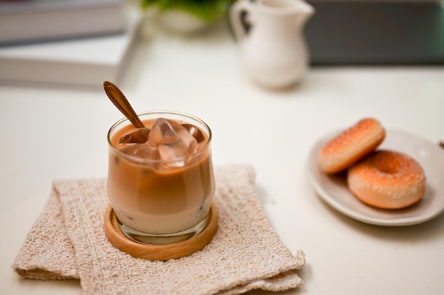 Een moderne kantoorwerkruimte met een iced latte en een bord met lekkere zoete donuts