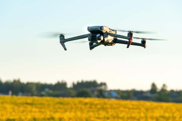 Een moderne quadcopter vliegt over een veld met zonnebloemen tegen de zonsondergang Het gebruik van moderne technologieën in het agro-industriële complex De drone helpt de boer in de agribusiness