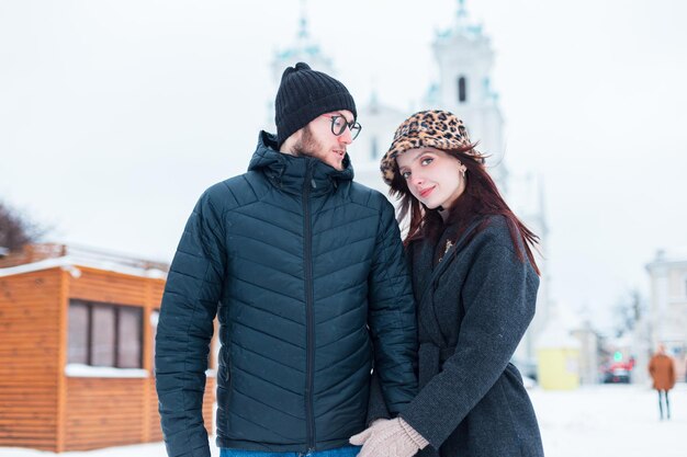 Een modieus mooi meisje en een knappe man in stijlvolle winterkleding lopen samen door de stad.