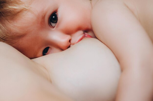 Een moeder die haar kleine baby borstvoeding geeft in haar armen close-up moeder die het kleine kind verzorgt en voedt