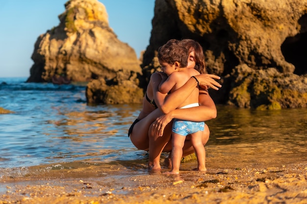 Een moeder die haar zoon knuffelt op het strand van Praia dos Arrifes Algarve strand Albufeira Portugal