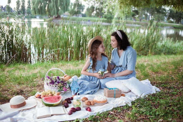 Foto een moeder en dochter op een picknick in een park aan de oevers van een rivier