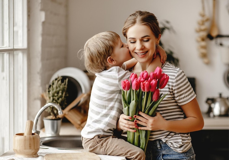 Foto een moeder en haar zoon houden een boeket tulpen vast.