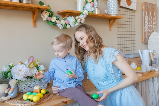 Een moeder en haar zoon in een in de lente ingericht huis vieren traditionele paasvakantie