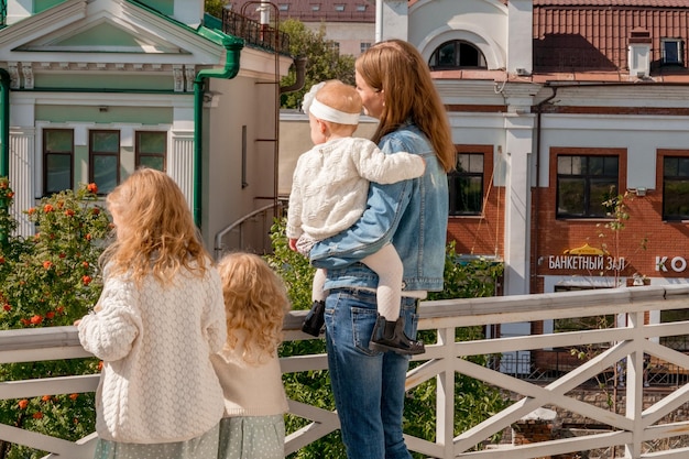 Een moeder met drie kinderen reist naar Europa Moeder en drie dochters bewonderen het uitzicht op de brug in Europa Moeder van veel kinderen op zomervakantie met kinderen