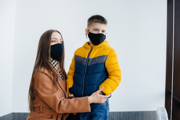 Een moeder met haar kind staat tijdens de quarantaine in een masker. Pandemie, coronavirus