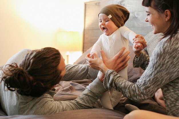 Een moeder vader en jonge baby samen thuis