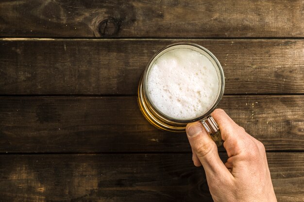 Een mok bier op de tafel.