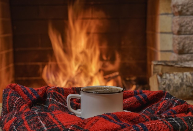 Een mok thee en wollen ding bij een gezellige open haard in een landhuis winter- of herfstvakantie