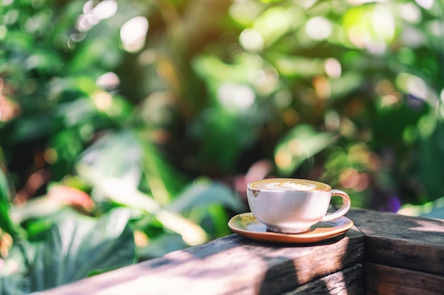 Een mok warme koffie op een houten balkon in de tuin