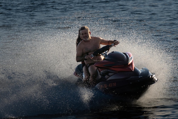 Een monitor en een meisje genieten van de jetski die met hoge snelheid langs het strand van Boiro slipt