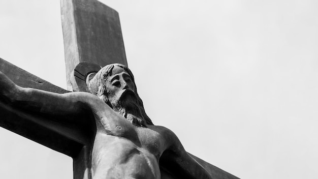 Foto een monochrome foto van een kruisigingssculptuur tegen de achtergrond van de lucht