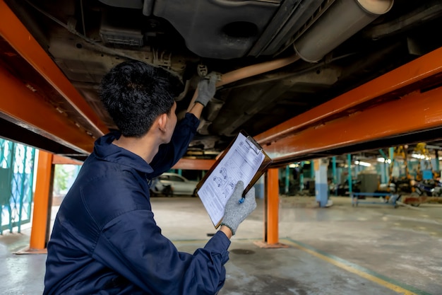 Een monteur service auto in garage is check a list auto's.