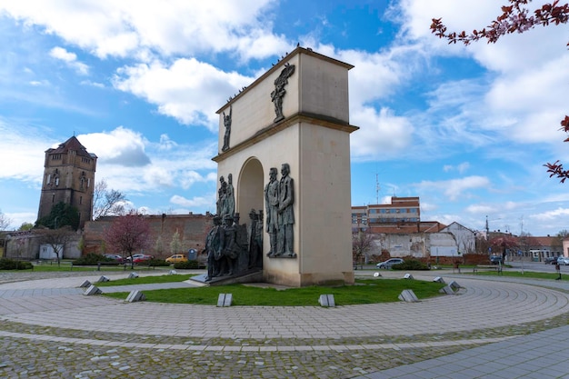 Een monument in een park met een boom op de achtergrond