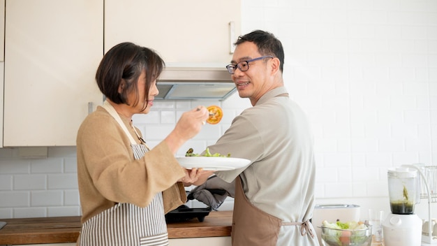 Een mooi Aziatisch echtpaar geniet van het eten nadat ze het samen in de keuken hebben gekookt