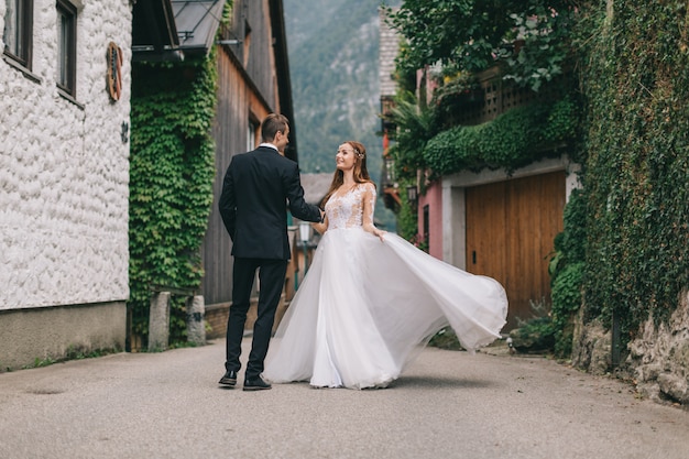 Een mooi bruidspaar loopt in een fee Oostenrijkse stad, Hallstatt.