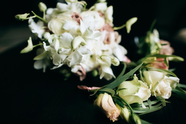 Een mooi huwelijksboeket van bruiden van witte bloemen op een donkere houten achtergrondx9